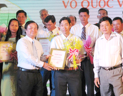 Le Minh Hoan, chairman of the People’s Committee of Dong Thap Province grants certificates of merit to farmers at a ceremony held to acknowledge their hard work and good production practices